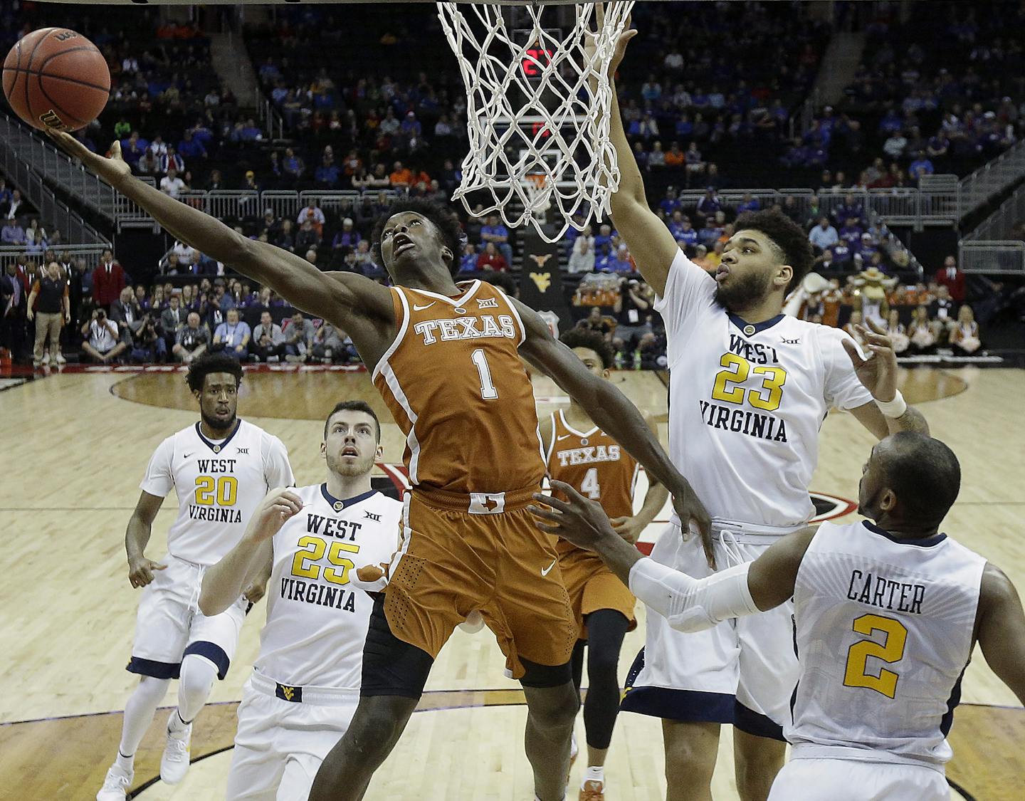 Texas' Andrew Jones (1) gets past West Virginia's Esa Ahmad (23) to shoot during the first half of an NCAA college basketball game in the quarterfinal round of the Big 12 tournament in Kansas City, Mo., Thursday, March 9, 2017. (AP Photo/Charlie Riedel) ORG XMIT: MOCR114