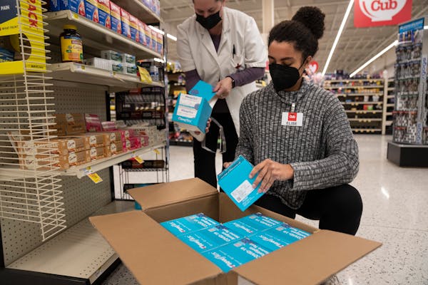 Pharmacist Jennifer Riss and pharmacy student Elise Moore stocked a single box of COVID-19 at-home tests on Wednesday at Cub Foods Pharmacy in St. Lou