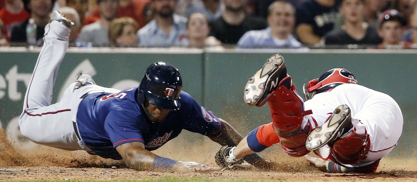 Boston Red Sox's Sandy Leon, right, fails to put the tag on Minnesota Twins' Kennys Vargas at home plate on an RBI-single by Eddie Rosario during the seventh inning of a baseball game in Boston, Saturday, July 23, 2016. (AP Photo/Michael Dwyer)