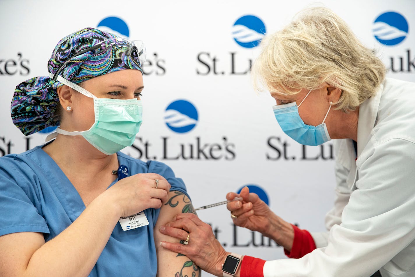 ICU nurse Sam Moder, left, received the first dose of the Pfizer COVID-19 vaccine at St. Luke's Hospital in Duluth from Sherry Johnson, a nurse practitioner.