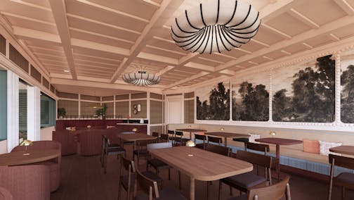A long room with wood tables, a bar at the back and walls with prints of black and white trees.