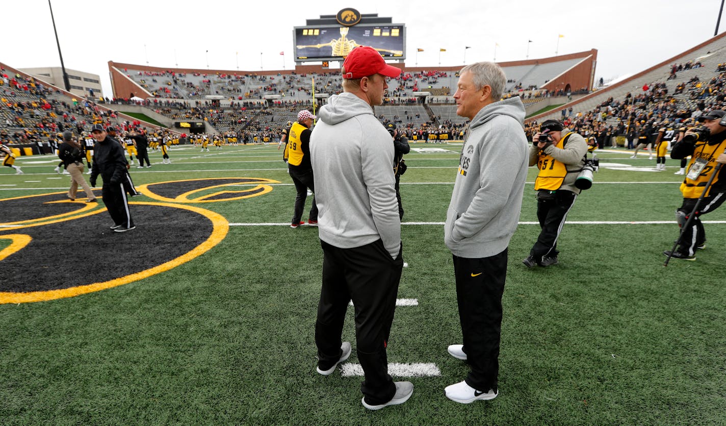 Nebraska head coach Scott Frost, left, talks with Iowa head coach Kirk Ferentz before an NCAA college football game, Friday, Nov. 23, 2018, in Iowa City, Iowa. (AP Photo/Charlie Neibergall)