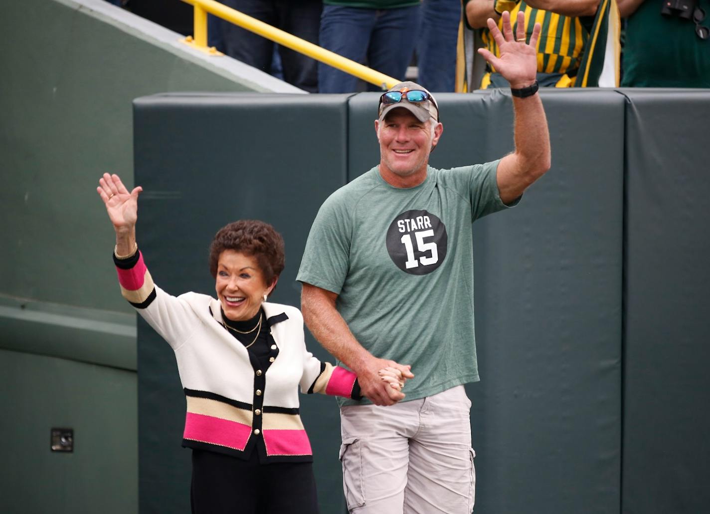 Former Green Bay Packers quarterback Brett Favre escorts Cherry Louise Morton, wife of former Green Bay Packers Bart Starr out of the tunnel before an NFL football game between the Green Bay Packers and the Minnesota Vikings Sunday, Sept. 15, 2019, in Green Bay, Wis. (AP Photo/Matt Ludtke)