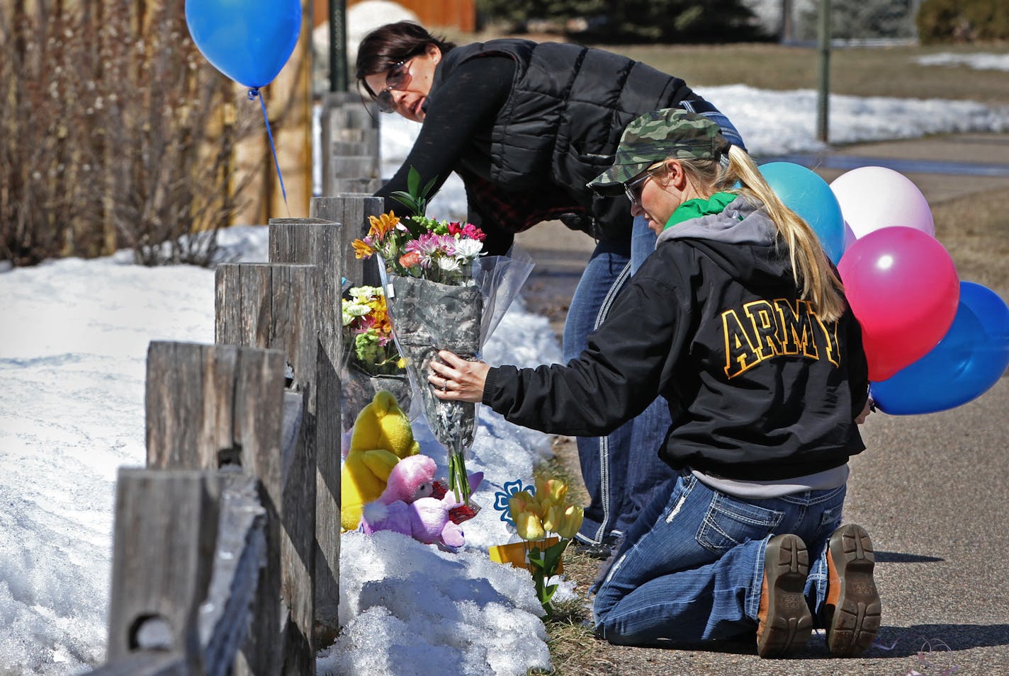 Jodie Weg&#xad;leitner, left, and Amanda Stenberg placed flowers at the Shields home in Zimmerman. The husbands of the two women serve in the National Guard with Mark Shields, husband of Stephanie Shields. Bruce Bisping