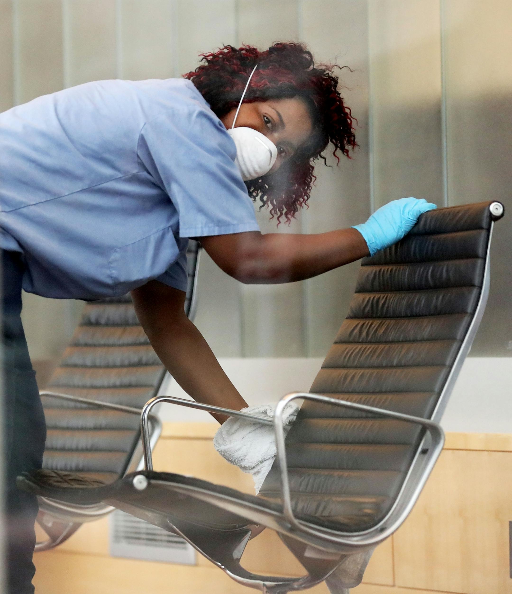 A worker sanitizes furniture at the downtown Minneapolis Public Library, a day after the library temporarily closed and was seen Wednesday, March 18, 2020, in Minneapolis, MN.