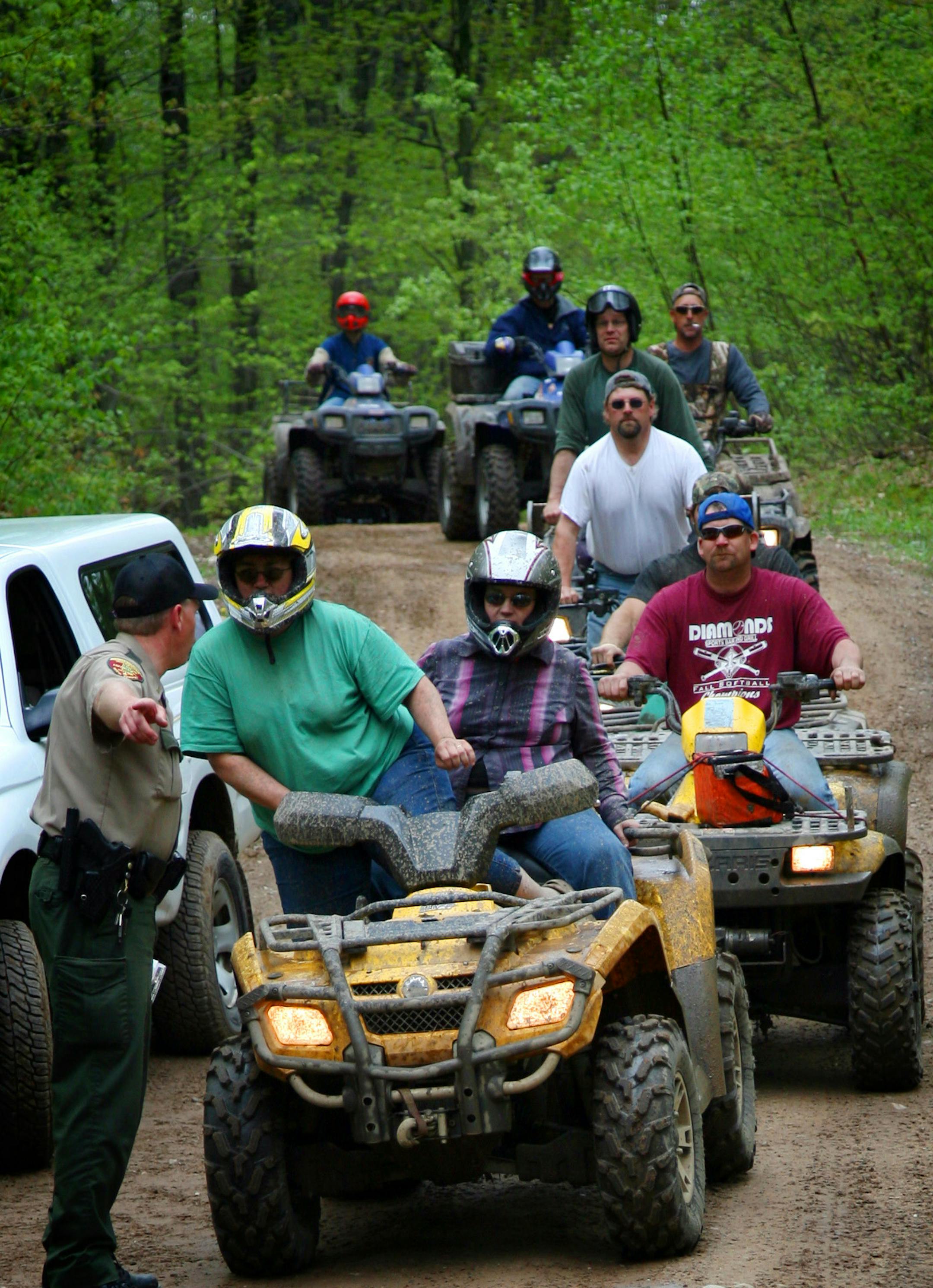 On a busy day on the Pine Center Trail, Department of Natural Resources Conservation Officer Paul Kuske checks registration of ATV riders. Ten years ago, ATV enforcement was a minor part of a CO's job. Now, ATV's are the third largest drain on their enforcement time, but the numbers of officers is about the same as a decade ago.