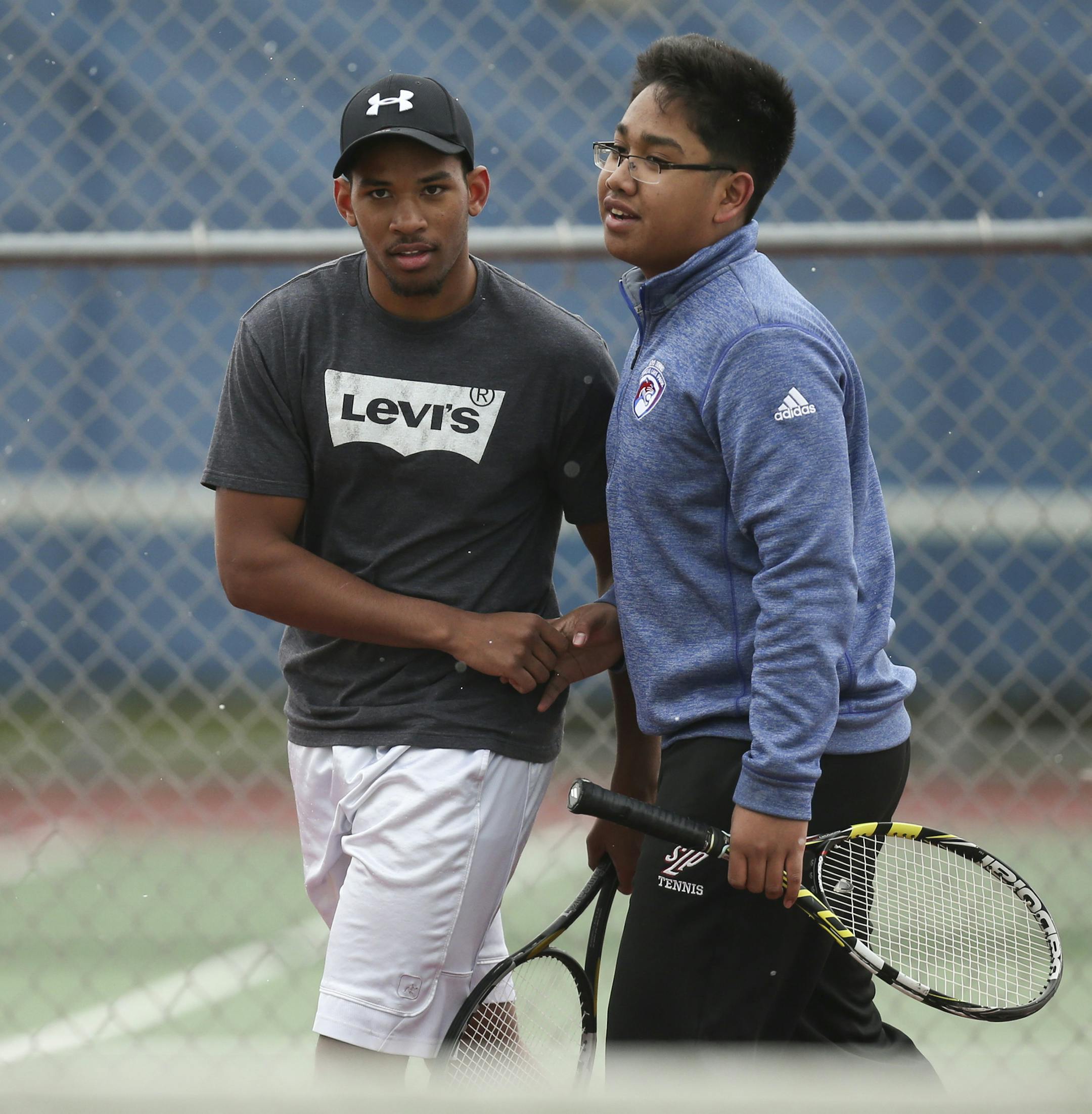 Spring Lake Park's no. 2 singles player, Darnelle Lyng, left, and Matthew Aribowo, the no. 1 singles player, congratulated each other after another win when they were paired as partners in some quick doubles matches at the end of practice Tuesday afternoon. ] JEFF WHEELER ï jeff.wheeler@startribune.com The Spring Lake Park tennis team practiced after school in occasional snow flurries Tuesday afternoon, April 12, 2016.
