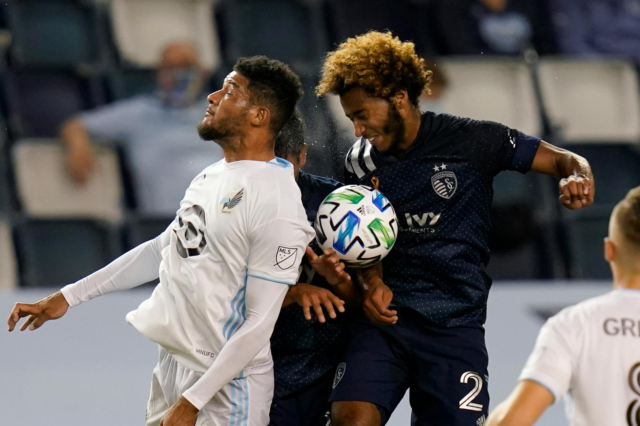 Minnesota United defender James Musa, left, heads the ball against Sporting Kansas City forward Gianluca Busio
