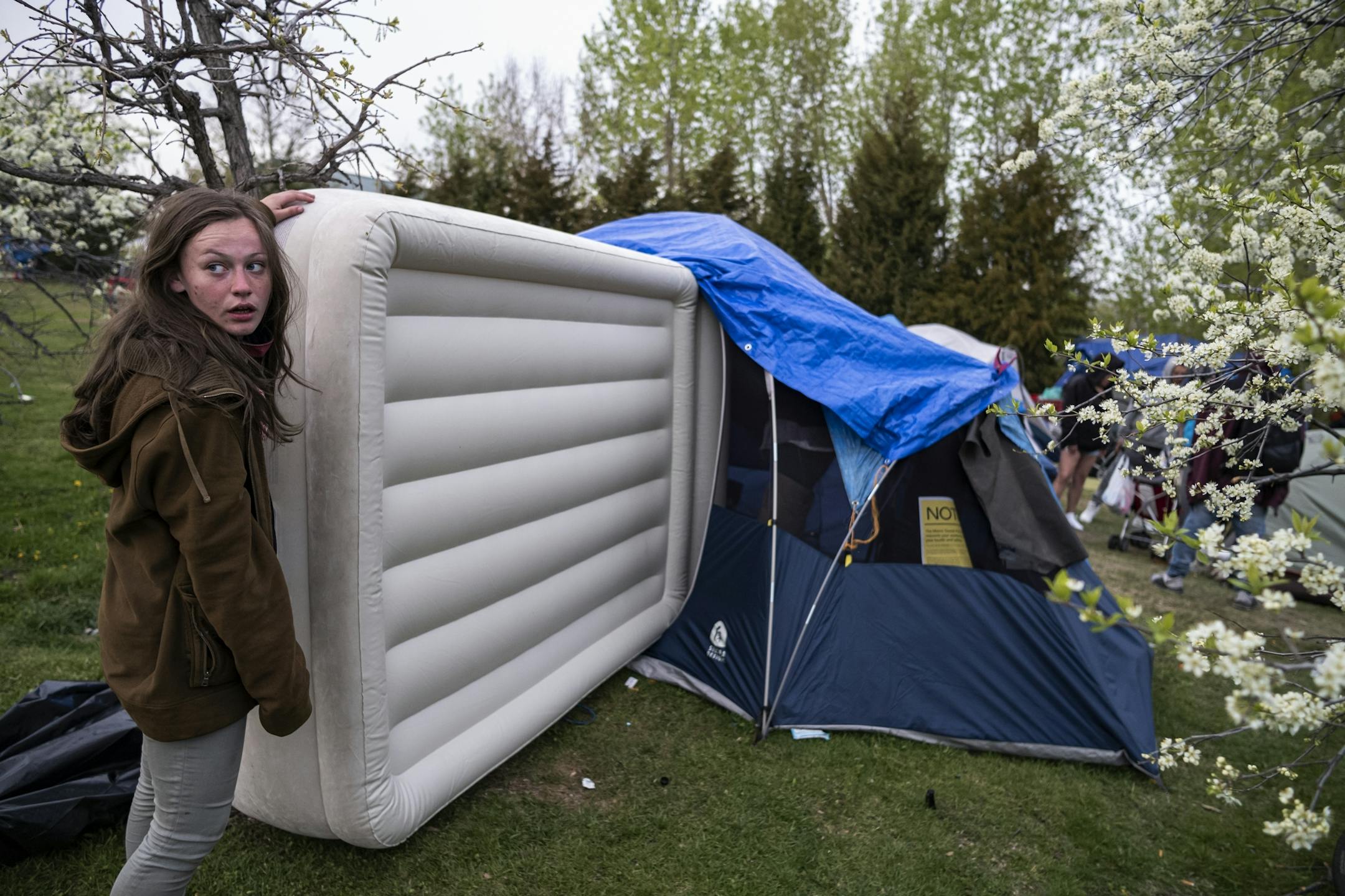 Residents try to move mattresses and other items so that they can into their tents as comfortable as possible.