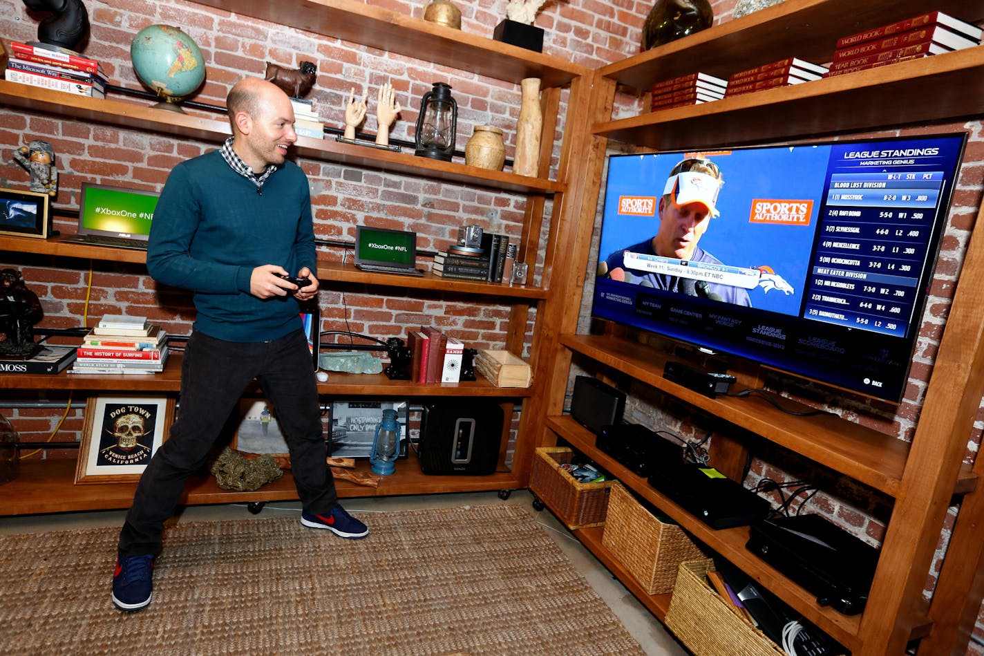 IMAGE DISTRIBUTED FOR XBOX - Paul Scheer of The League uses The NFL on Xbox One to check his fantasy team, on Sun., Nov. 17, 2013 in Venice Beach, Calif. (Photo by Casey Rodgers/Invision for Xbox/AP Images)