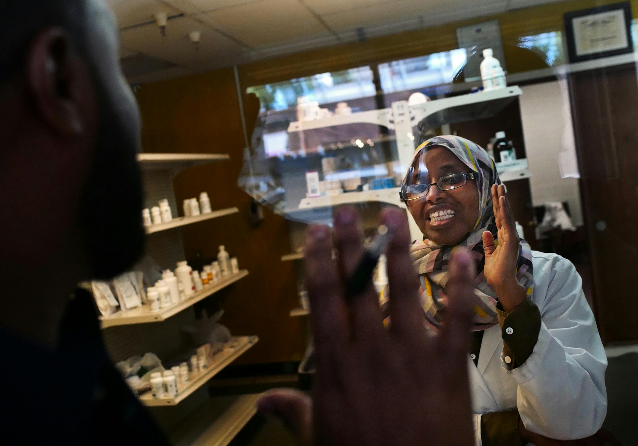 Burhan Elmi, tries to convince pharmacist Saida Mohamed, owner of Lakes Pharmacy to participate on a Sunday for Open Streets. Mohamed explained that Sunday is her only day off. She relented and offered to be open for a couple hours.