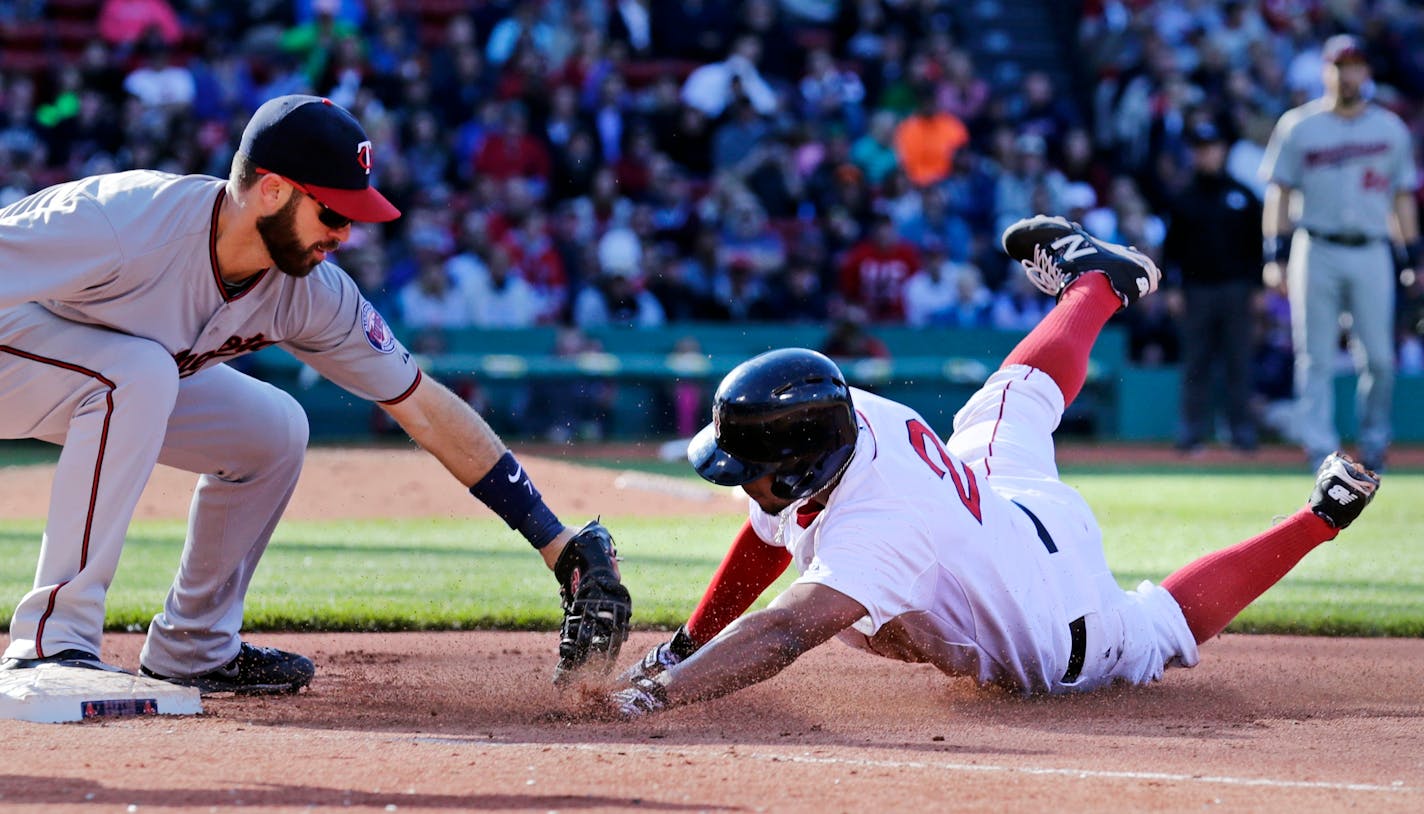 Minnesota Twins first baseman Joe Mauer, left, tags out Boston Red Sox's Xander Bogaerts diving back to first on an unsuccessful steal attempt in the fifth inning during a baseball game at Fenway Park in Boston, Thursday, June 4, 2015. (AP Photo/Charles Krupa)