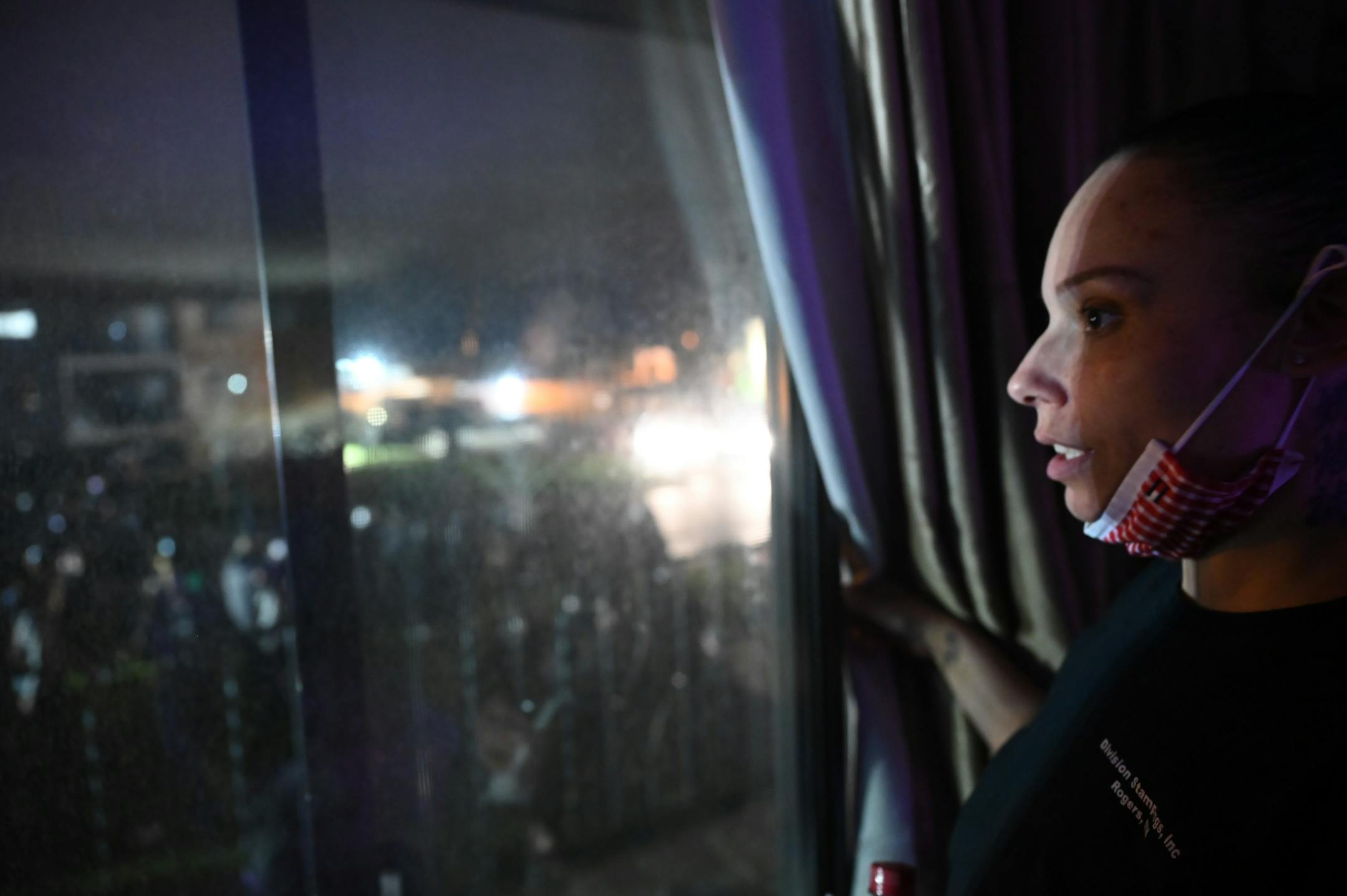 Angela Johnson, a resident across street from police department, watches chaos from her window. Johnson has been trying to study psychology and wants to be an addiction counselor. People were protesting near the Brooklyn Center Police Department in response to the fatal police shooting of Daunte Wright.