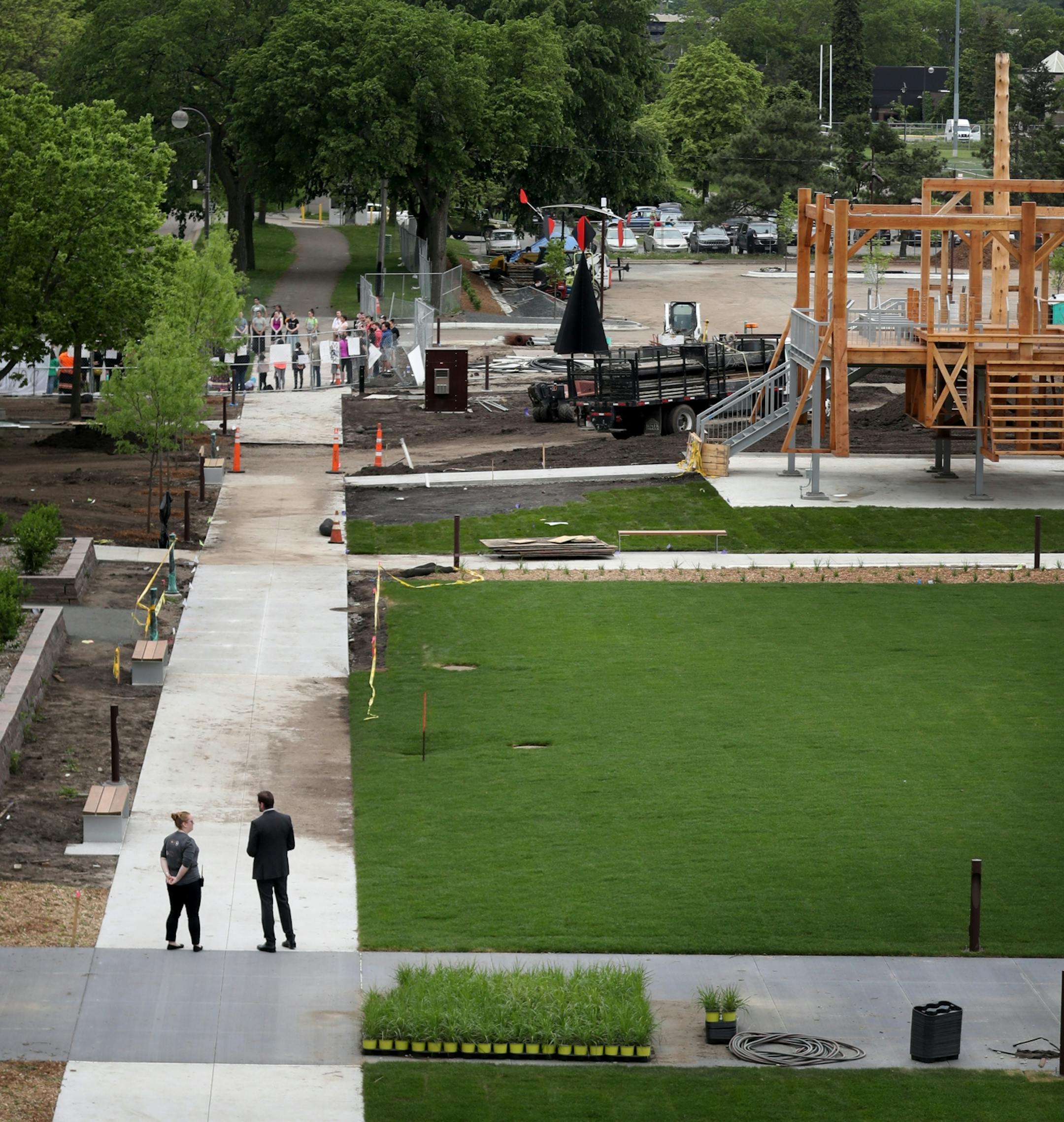 A controversial new sculpture at the Walker Art Center that prompted an outcry among Minnesota's American Indian communities will be dismantled, the director said Saturday. Here, seen from the Walker foot bridge, Walker Art Museum security watch the nearby protest outside the Walker Sculpture Garden Saturday, May 27, 2017, in Minneapolis, MN.