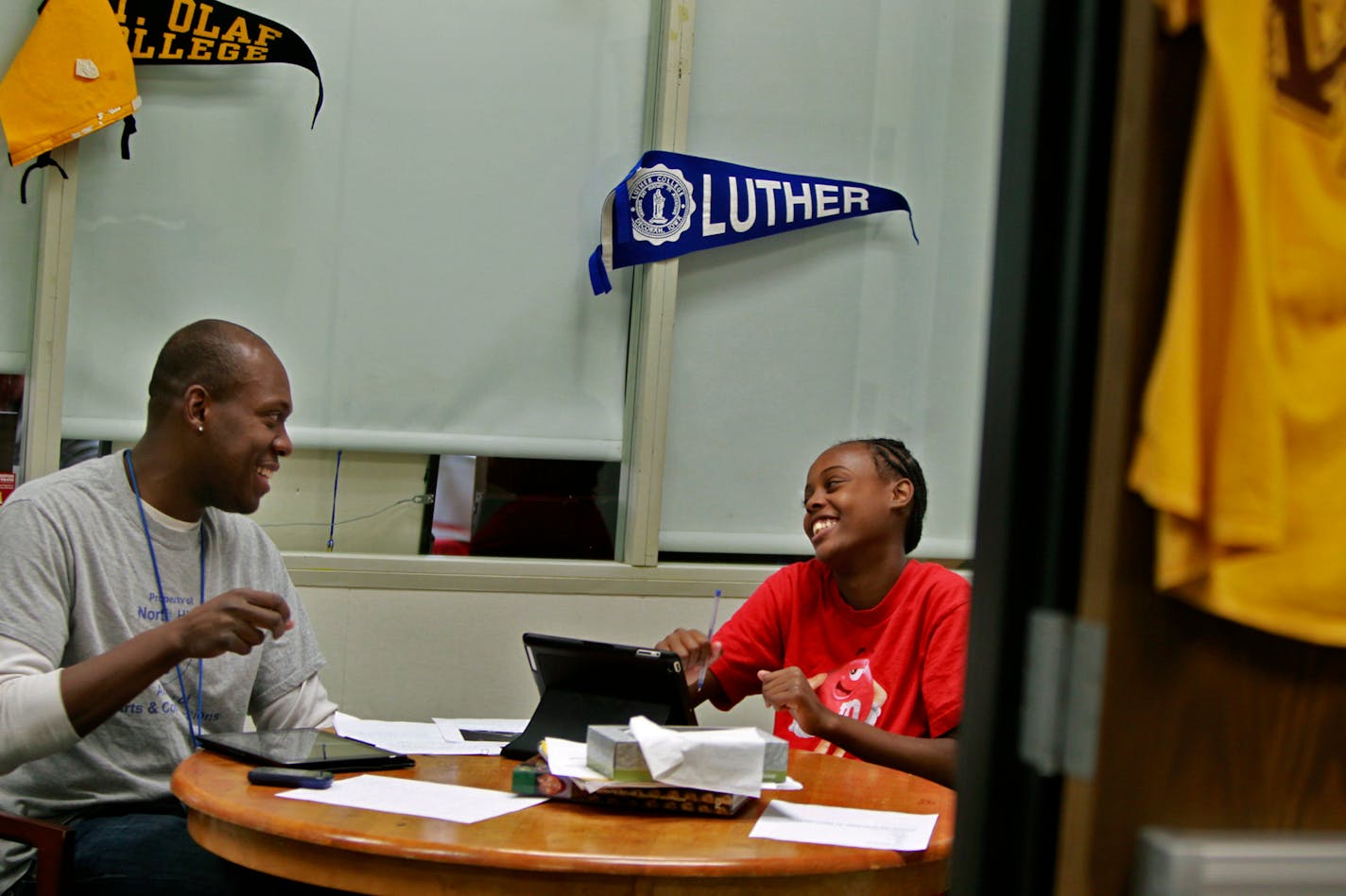 Counselor Derek Francis helped out student Renee Parks, 14, with her assignment on Minnesota Lynx Seimone Augustus at the new Academy of Arts and Communications program at North High School, Friday, October 5, 2012 in Minneapolis, MN. The Minneapolis school with more than a century of tradition, faced extinction not long ago. But Superintendent Bernadeia Johnson relented and the school welcomes a small class of freshmen with a new program, an outside consultant that's a first in Minneapolis, and questions about whether it can turn a corner academically and keep the promises it made to those new students.(ELIZABETH FLORES/STAR TRIBUNE) ELIZABETH FLORES ¥ eflores@startribune.com