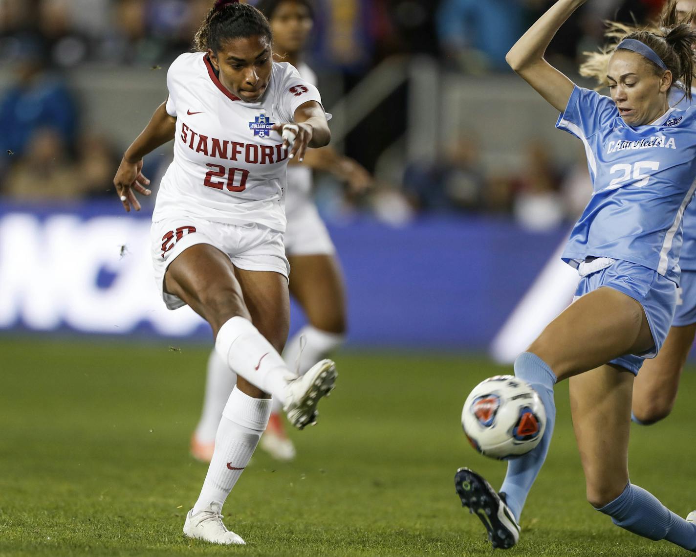 Stanford's Catarina Macario, left, shoots while being defended by North Carolina's Maycee Bell during the first half of a soccer match in San Jose, Calif., Dec. 8, 2019. Brazilian-born Stanford midfielder Macario is among the players who will take part in the U.S. women's national team training camp this month. The two-time winner of the MAC Hermann Trophy as the nation's best college player, Macario had a Stanford single-season record of 32 goals and 23 assists last year. This is the first time