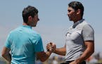 Jason Day, of Australia, and Rory McIlroy, of Ireland, shake hands after the second round of the U.S. Open golf tournament Friday, June 16, 2017, at E