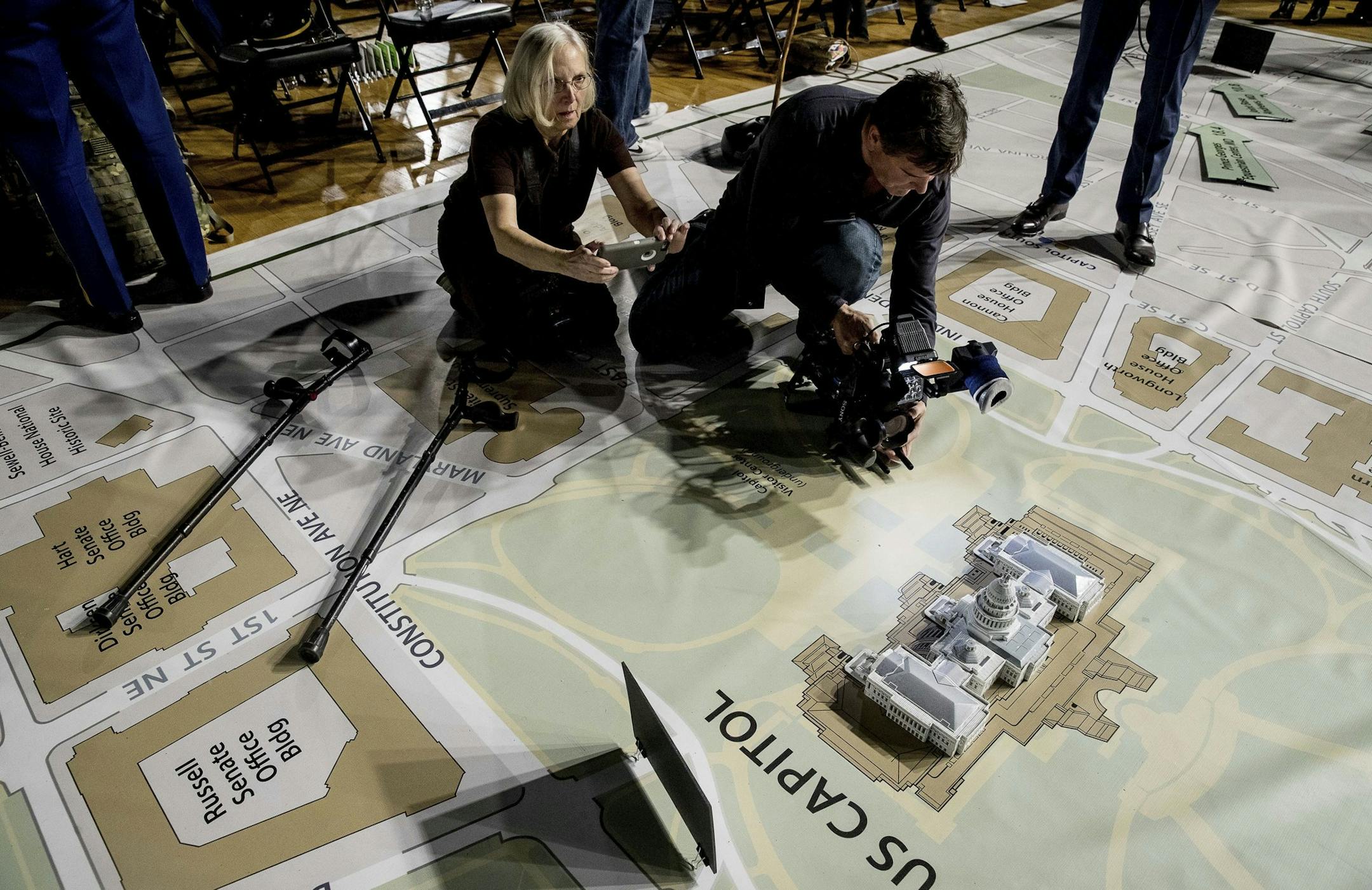 News photographers take photos of a model of the Capitol Building on a giant planning map during a media tour highlighting inaugural preparations being made by the Joint Task Force-National Capital Region for military and civilian planners, Wednesday, Dec. 14, 2016, at the DC Armory in Washington. (AP Photo/Andrew Harnik) ORG XMIT: DCAH108