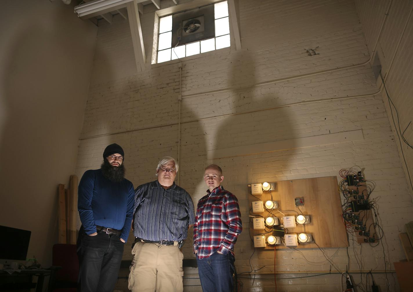 Power Over Time officials Nick Wormley, Ralph Jenson and Matthew Blackler, from left, near a bank of prototypes of their energy controllers.