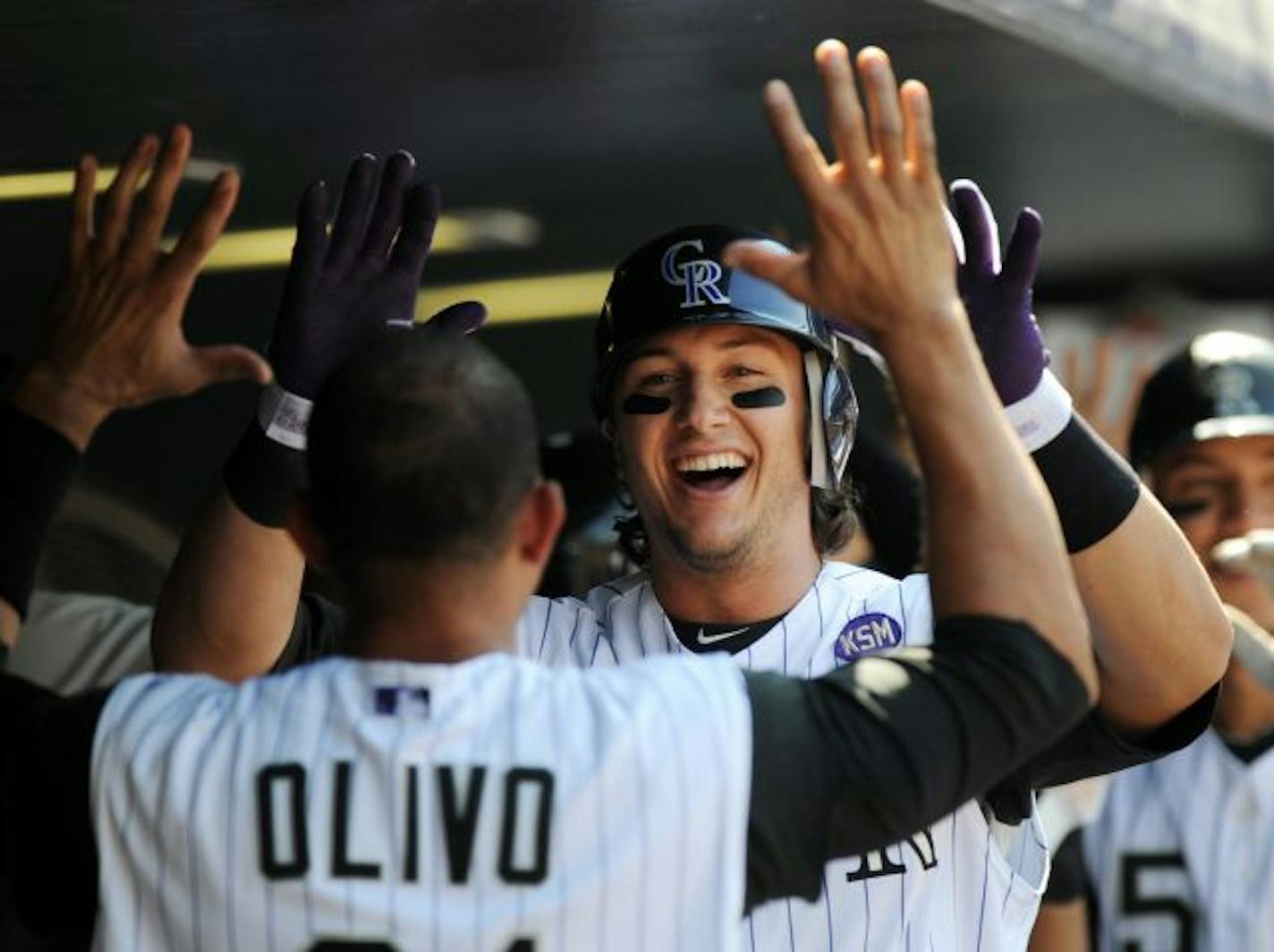 Colorado Rockies' Troy Tulowitzki high-fives with teammate Miguel Olivo in the dugout after a three-run home run in the fourth inning of a baseball game against the San Diego Padres at Coors Field in Denver on Wednesday, Sept. 15, 2010. The Rockies won 9-6 on two home runs by Tulowitzki.