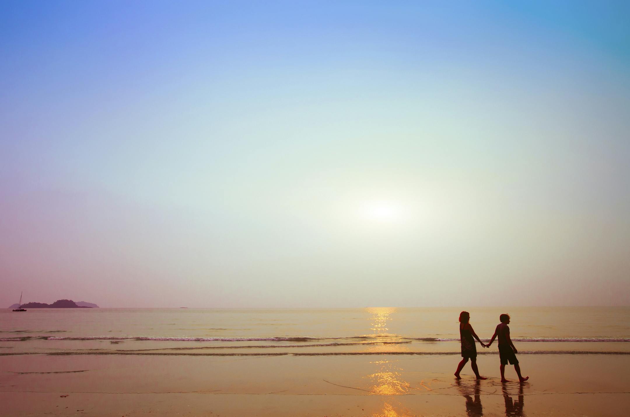 silhouettes of couple on the beach at sunset