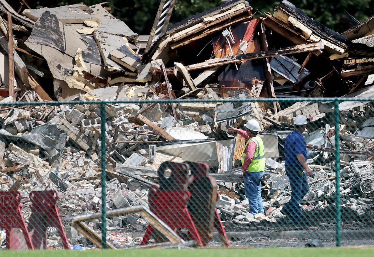 Two days after an explosion and building collapse at Minnehaha Academy that left two dead and several injured, officials look over the site Friday, Aug. 4, 2017, in Minneapolis.