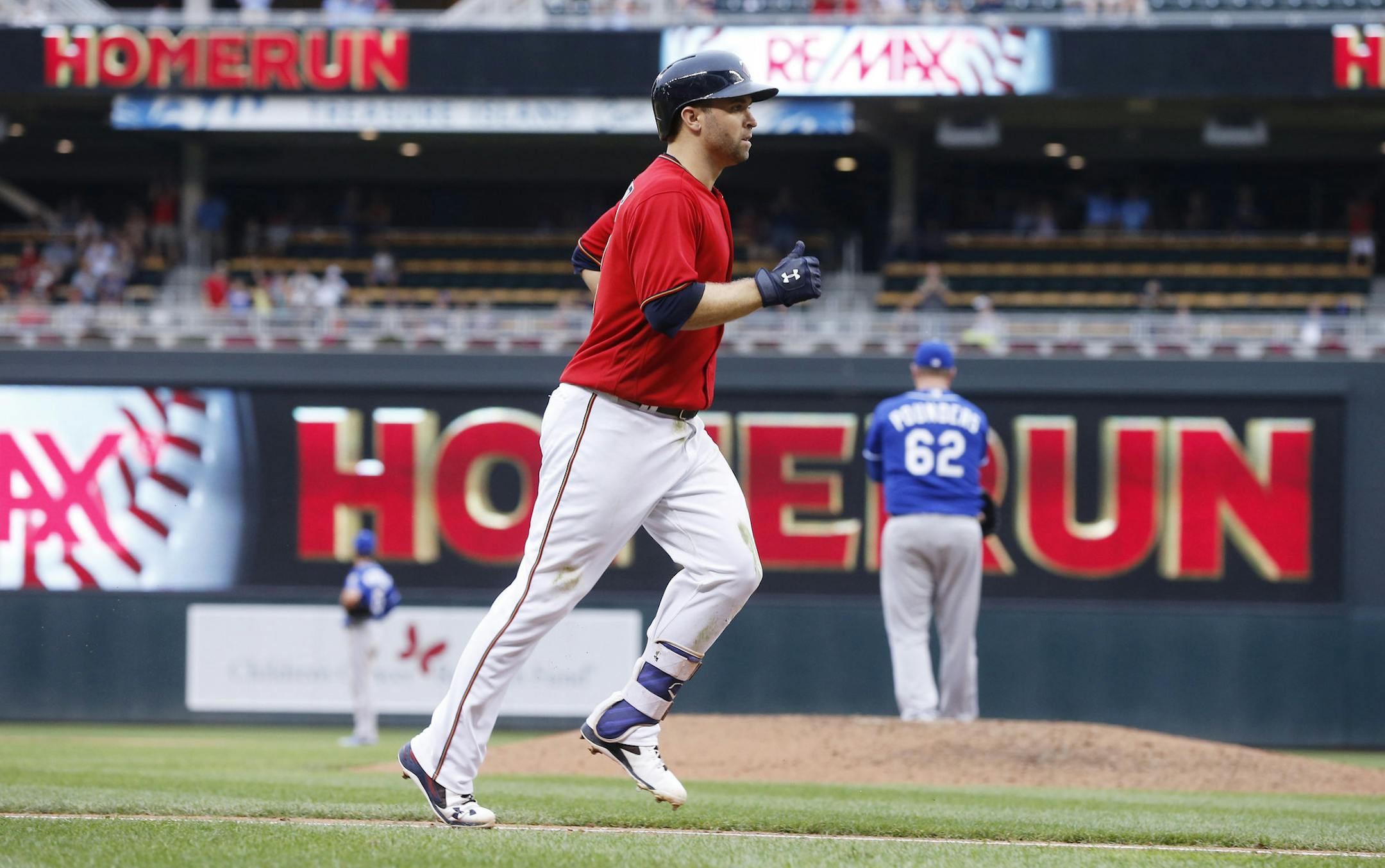 Minnesota Twins' Brian Dozier jogs home on his eighth-inning solo home run off Kansas City Royals pitcher Brooks Pounders, right, in a baseball game Monday, Sept. 5, 2016, in Minneapolis. It was Dozier's third home run of the game. The Royals won 11-5. (AP Photo/Jim Mone)