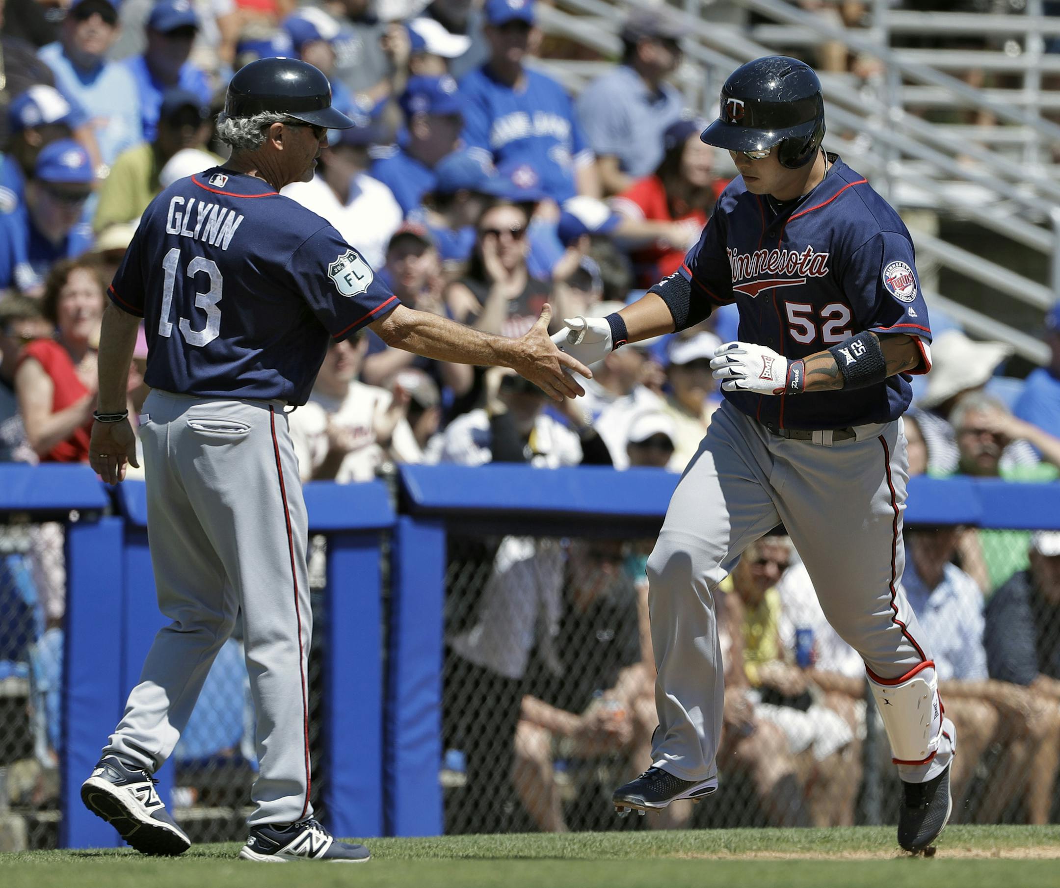 Minnesota Twins' Byung Ho Park (52) shakes hands with third base coach Gene Glynn after Park hit a two-run home run off Toronto Blue Jays starting pitcher Francisco Liriano during the fifth inning of a spring training baseball game Monday, March 20, 2017, in Dunedin, Fla. (AP Photo/Chris O'Meara)
