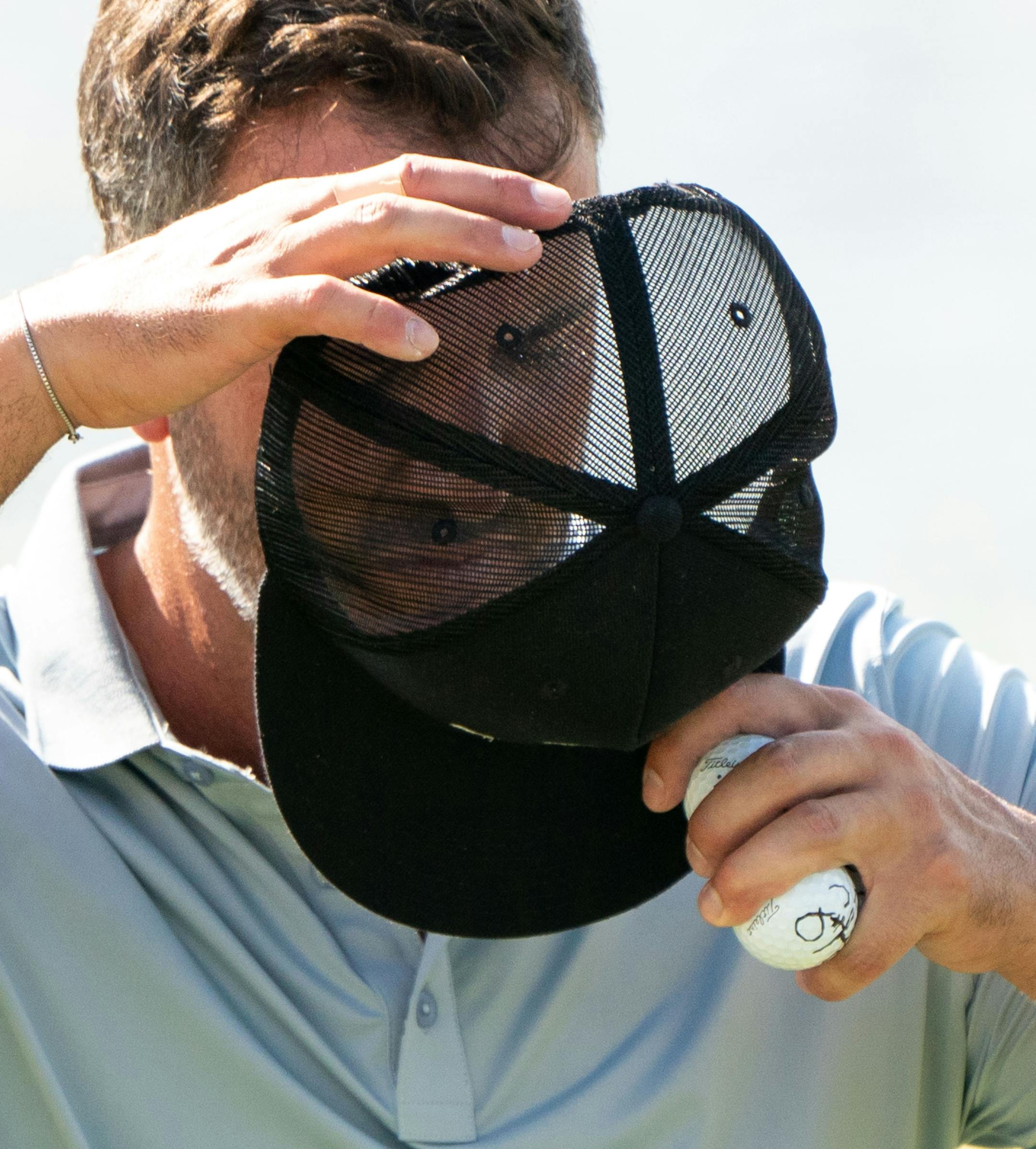 Scott Piercy puts his hat back on after finishing the 9th hole during the 3M Open.