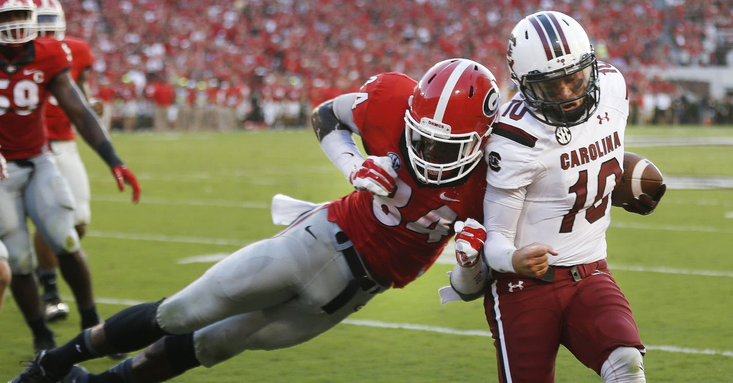 South Carolina quarterback Perry Orth (10) gets past Georgia linebacker Leonard Floyd (84) to score a touchdown during the first half of an NCAA college football game Saturday, Sept. 19, 2015, in Athens, Ga. (AP Photo/John Bazemore) ORG XMIT: GAJB107