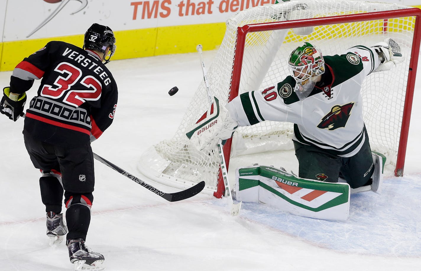 Carolina Hurricanes' Kris Versteeg (32) has a shot on goal deflected by Minnesota Wild goalie Devan Dubnyk (40) during overtime of an NHL hockey game in Raleigh, N.C., Thursday, Nov. 12, 2015. Minnesota won 3-2. (AP Photo/Gerry Broome)