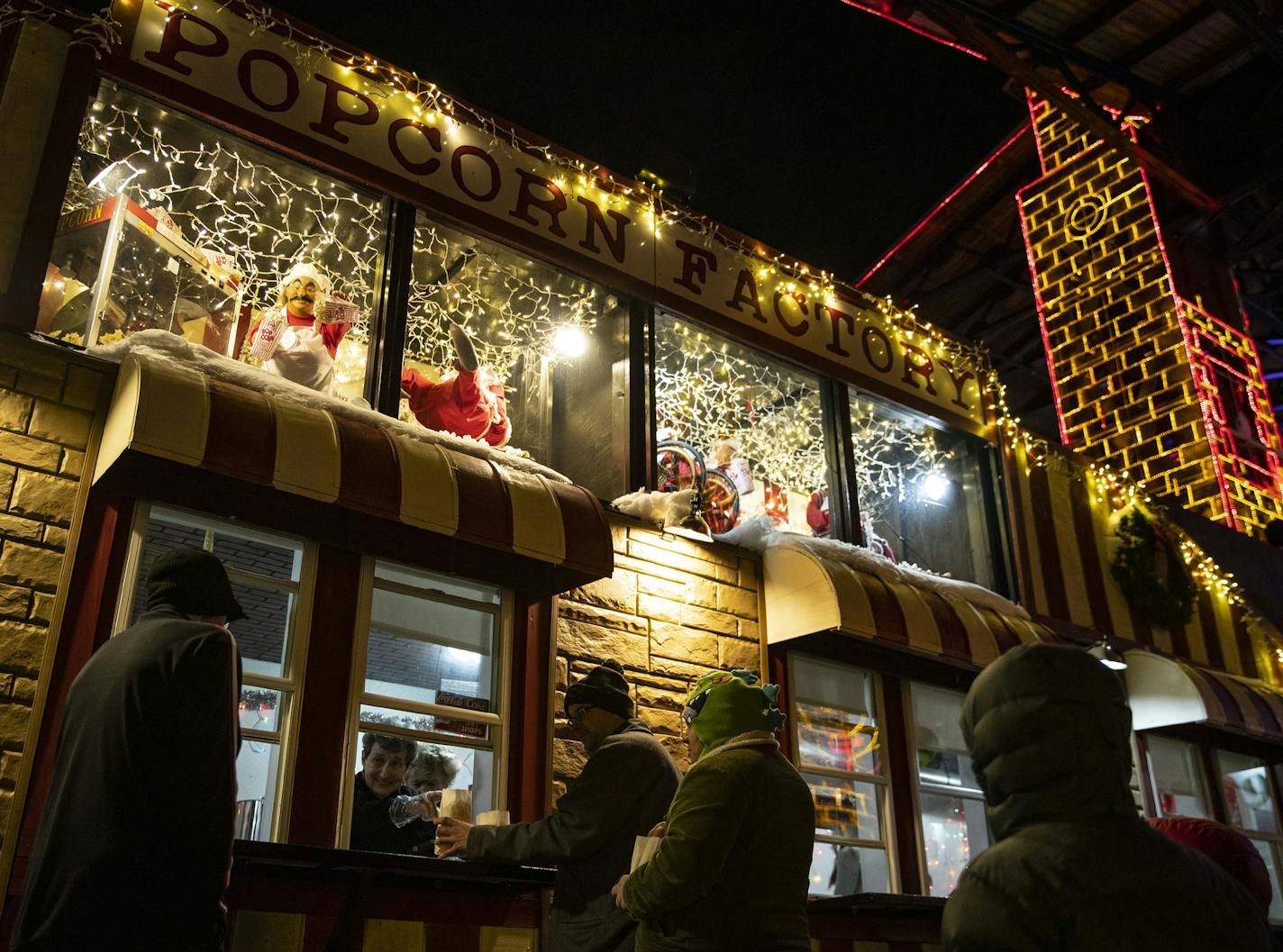 Visitors walked by and visited the popcorn stand in Bentleyville where animatronic elves making popcorn moved and came to life on Tuesday December 3, 2019. ]
ALEX KORMANN &#x2022; alex.kormann@startribune.com Bentleyville in Duluth, MN has the old Dayton's animatronic figures on display in faux TV sets and above their popcorn stand. These animatronics are favorites of people that visit the Christmas lights display.