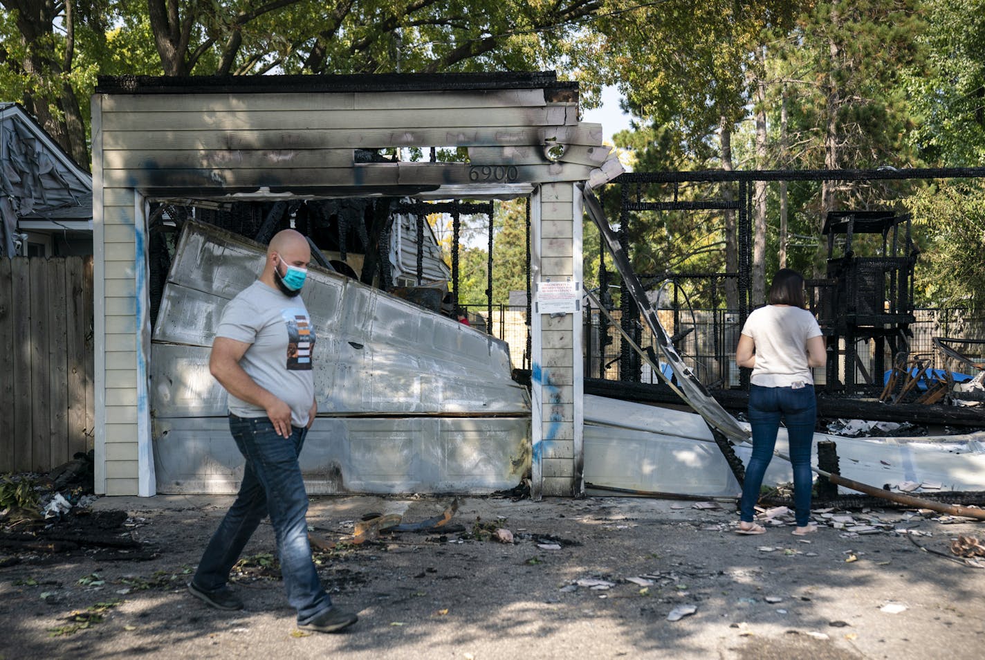 Dennis and Deana Molla walked through the destruction of their garage and cars after at 4 A.M. the morning they were set ablaze at their at home in Brooklyn Center, Minn., on Wednesday, September 23, 2020. The fire has been declared an arson. Dennis' truck had a trump flag in the back that was stolen recently but he had replaced it with a new one before the fire. ] RENEE JONES SCHNEIDER renee.jones@startribune.com