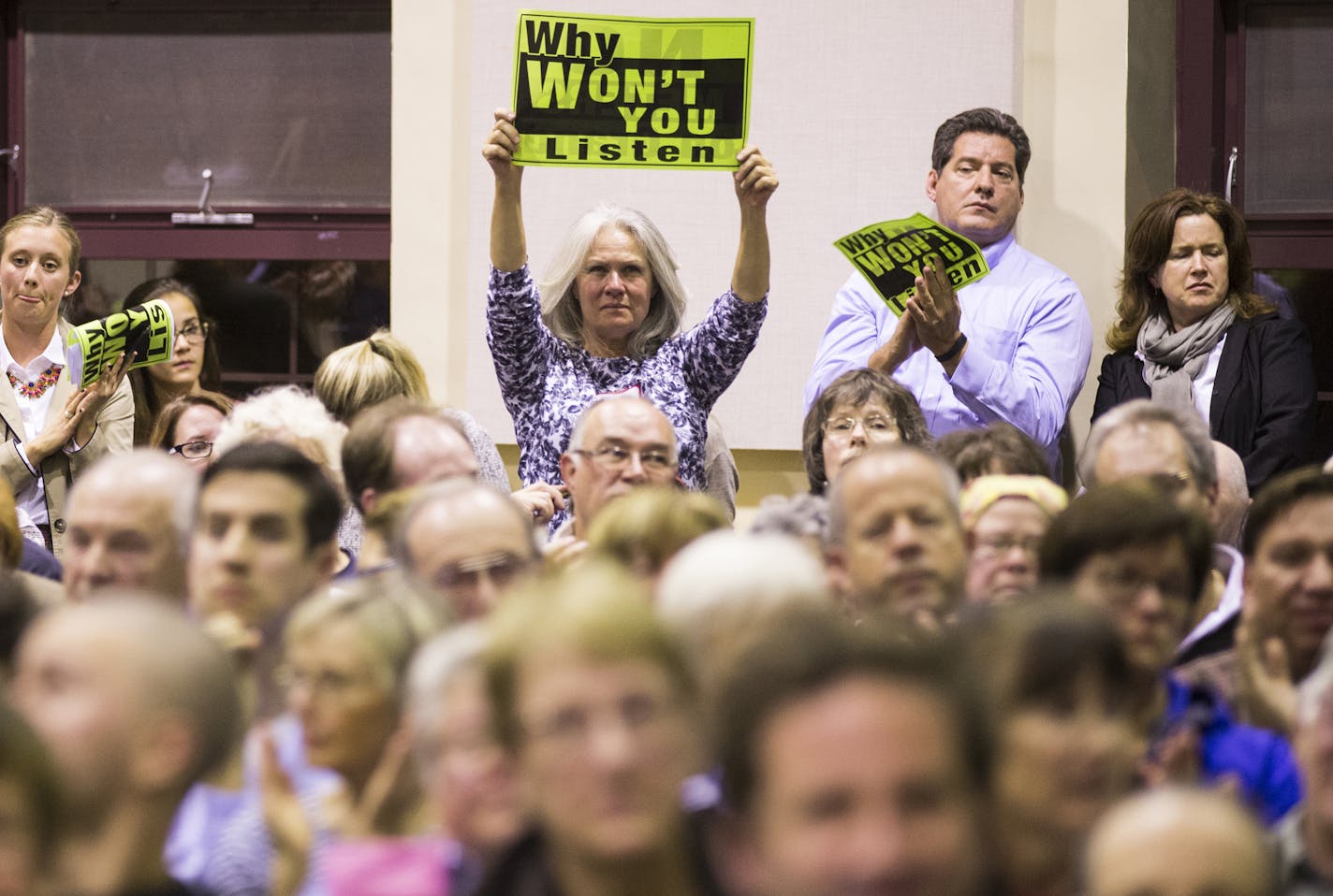 People opposed to parking meters on Grand Avenue hold up signs during a public meeting with St. Paul Mayor Chris Coleman at William Mitchell College of Law in St. Paul on Monday, October 19, 2015. ] (LEILA NAVIDI/STAR TRIBUNE) leila.navidi@startribune.com