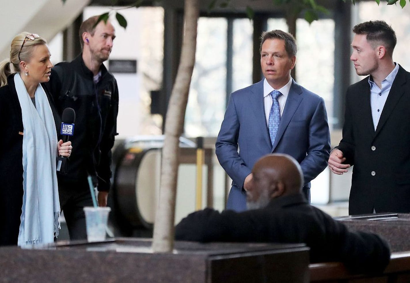 Media members approach Don Damond, the fiance of Justine Ruszczyk Damond, second from right, and Zach Damond, right, Damond's son, as they arrive for the opening arguments in the trial of former Minneapolis police officer Mohamed Noor at the Hennepin County Government Center for Tuesday, April 9, 2019, in Minneapolis, MN.