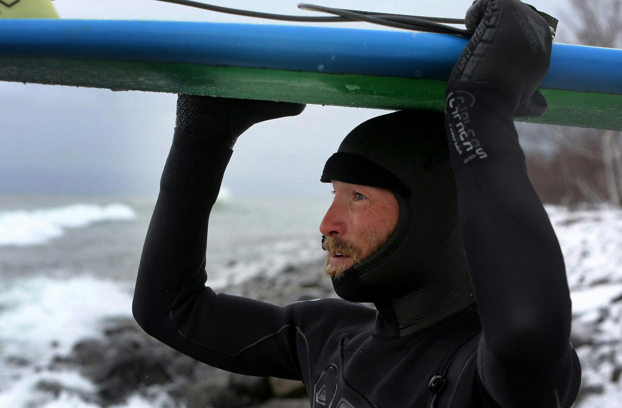 Surfer Mike Jost of Alexandria marvels at the size of the waves on Lake Superior after taking a break and coming back for more surfing Thursday, March 17, 2016, at Stony Point, near Two Harbors, MN. A passing front dropped some snow but also brought a stiff north wind, bringing waves nearing 10 feet and a small army of surfers.](DAVID JOLES/STARTRIBUNE)djoles@startribune.com A few years back, there were just a few men who dared surf Lake Superior. But this winter, after a winter storm, dozens of