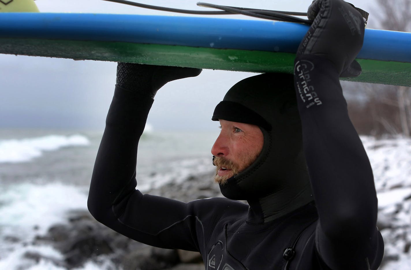 Surfer Mike Jost of Alexandria marvels at the size of the waves on Lake Superior after taking a break and coming back for more surfing Thursday, March 17, 2016, at Stony Point, near Two Harbors, MN. A passing front dropped some snow but also brought a stiff north wind, bringing waves nearing 10 feet and a small army of surfers.](DAVID JOLES/STARTRIBUNE)djoles@startribune.com A few years back, there were just a few men who dared surf Lake Superior. But this winter, after a winter storm, dozens of