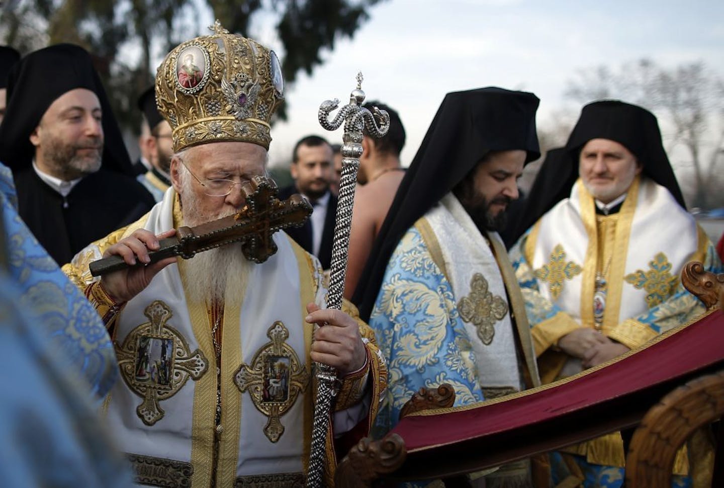 Ecumenical Patriarch Bartholomew I, the spiritual leader of the world's Orthodox Christians, kisses a wooden cross before throwing it toward swimmers into the waters during a ceremony to bless the water at the Golden Horn in Istanbul, Wednesday, Jan. 6, 2016. The traditional ceremony marks the Epithany in Istanbul when Bartholomew I or an Orthodox priest throws a simple wooden cross into the water and swimmers race to be the first to retrieve it.