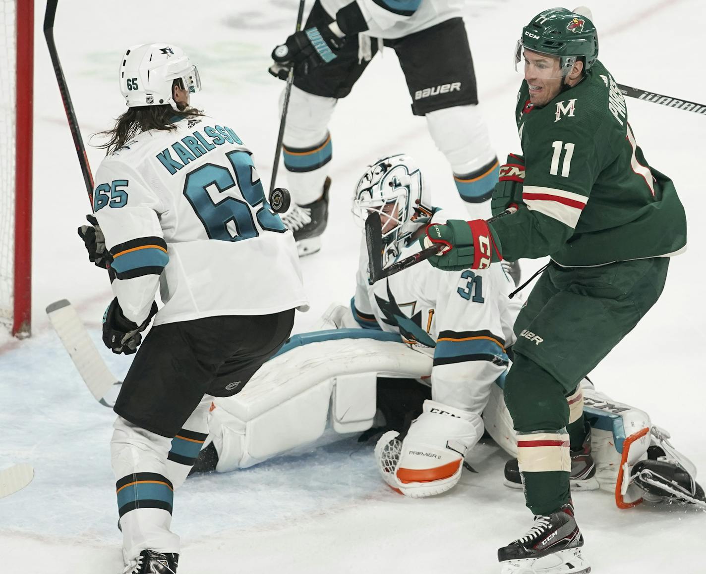 Minnesota Wild left wing Zach Parise (11) tried to slap a flying puck into the net with goaltender Martin Jones out of position and San Jose Sharks defenseman Erik Karlsson (65) in his way. ] JEFF WHEELER &#xef; jeff.wheeler@startribune.com The Minnesota Wild were shut out by the San Jose Sharks 4-0 in an NHL hockey game Tuesday night, December 18, 2018 at Xcel Energy Center in in St. Paul.