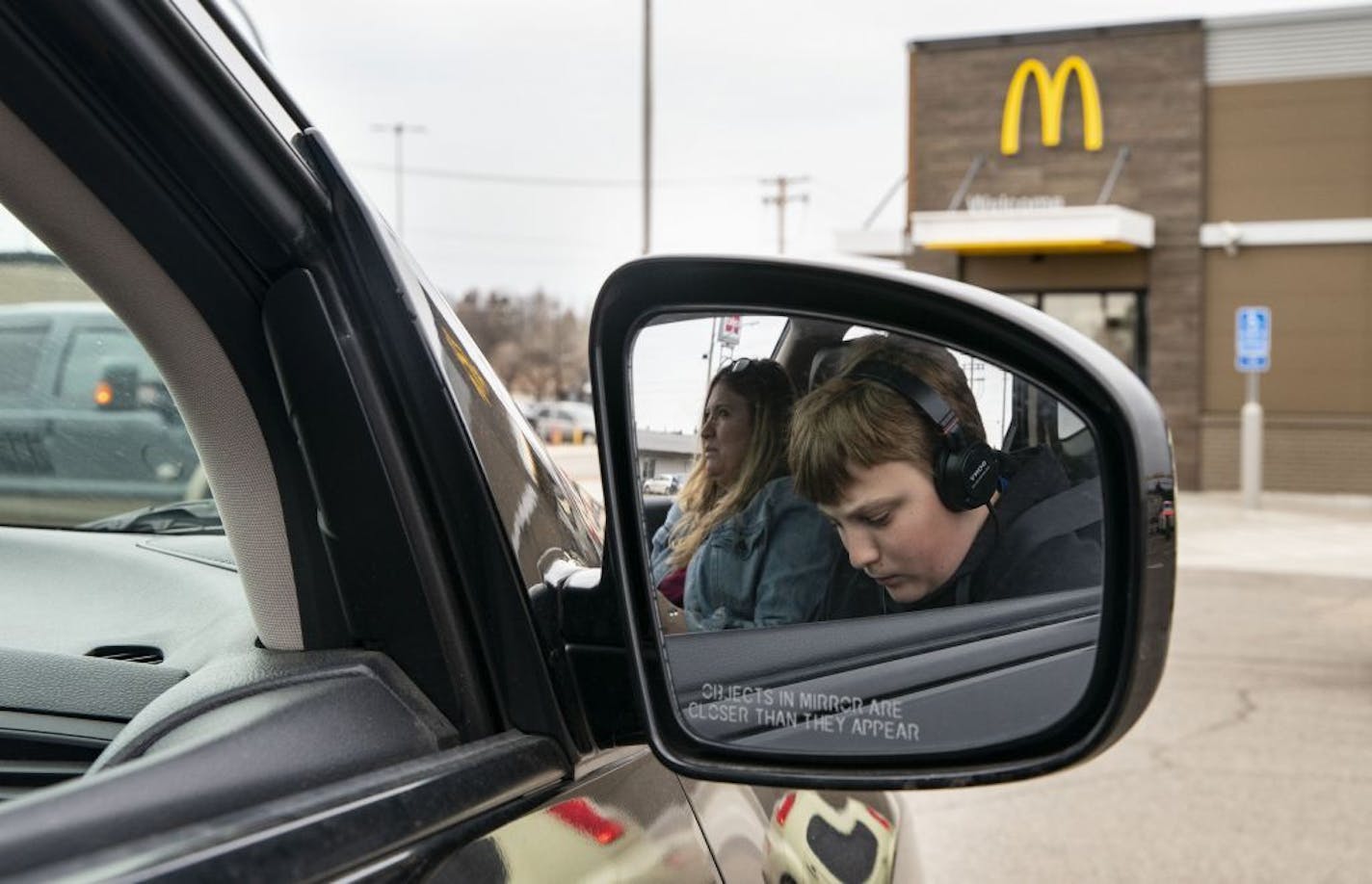 Colton Rebarich worked on choir homework while his mom, Nancy, checked her phone while parked outside a McDonalds in Virginia, Minn. They go there twice a week to access the internet for homework and assignments.