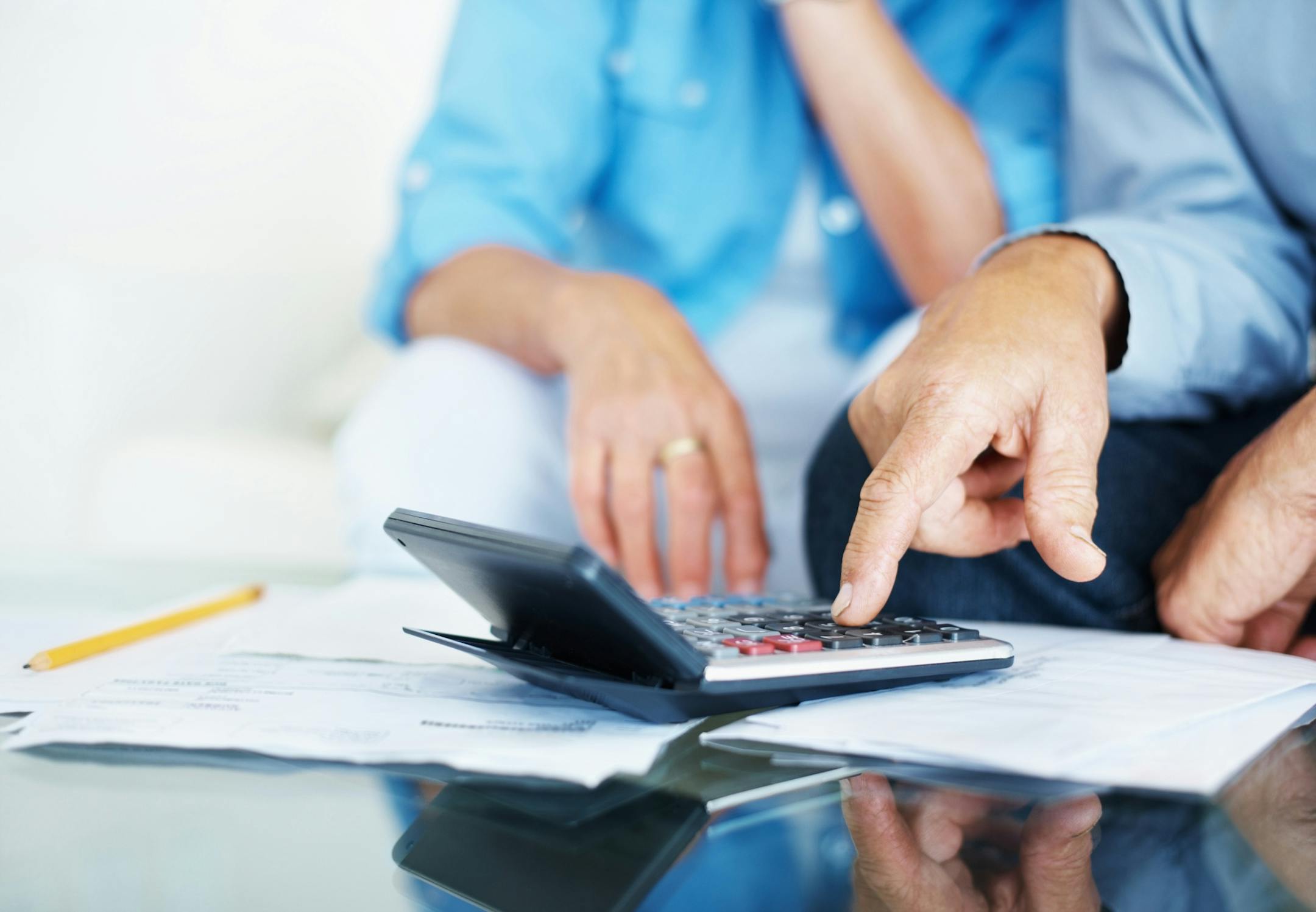 Closeup of a senior man's hand calculating bills at home
