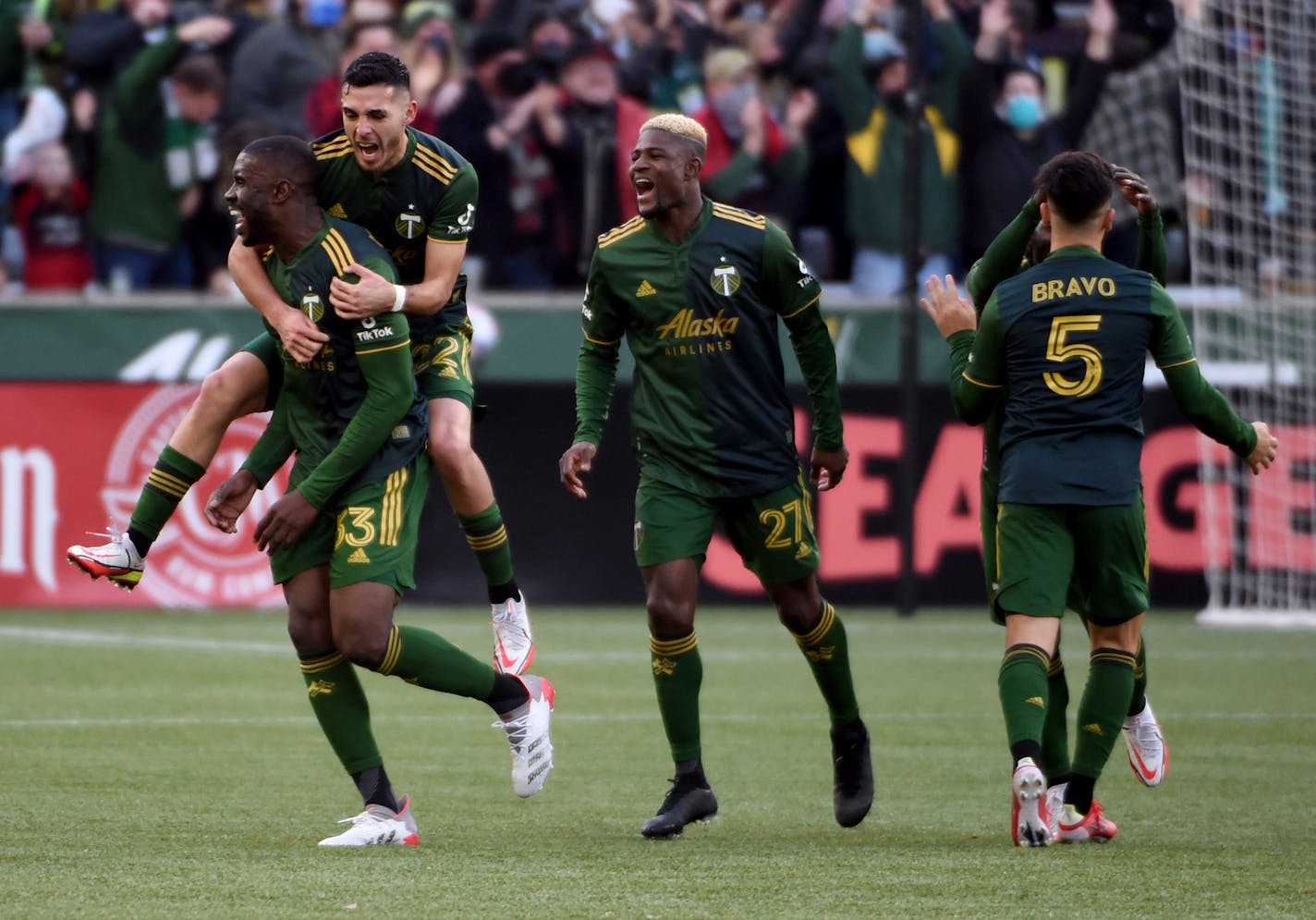 Portland Timbers defender Larrys Mabiala, left, is mobbed by teammates after scoring a goal during the first half against Minnesota United