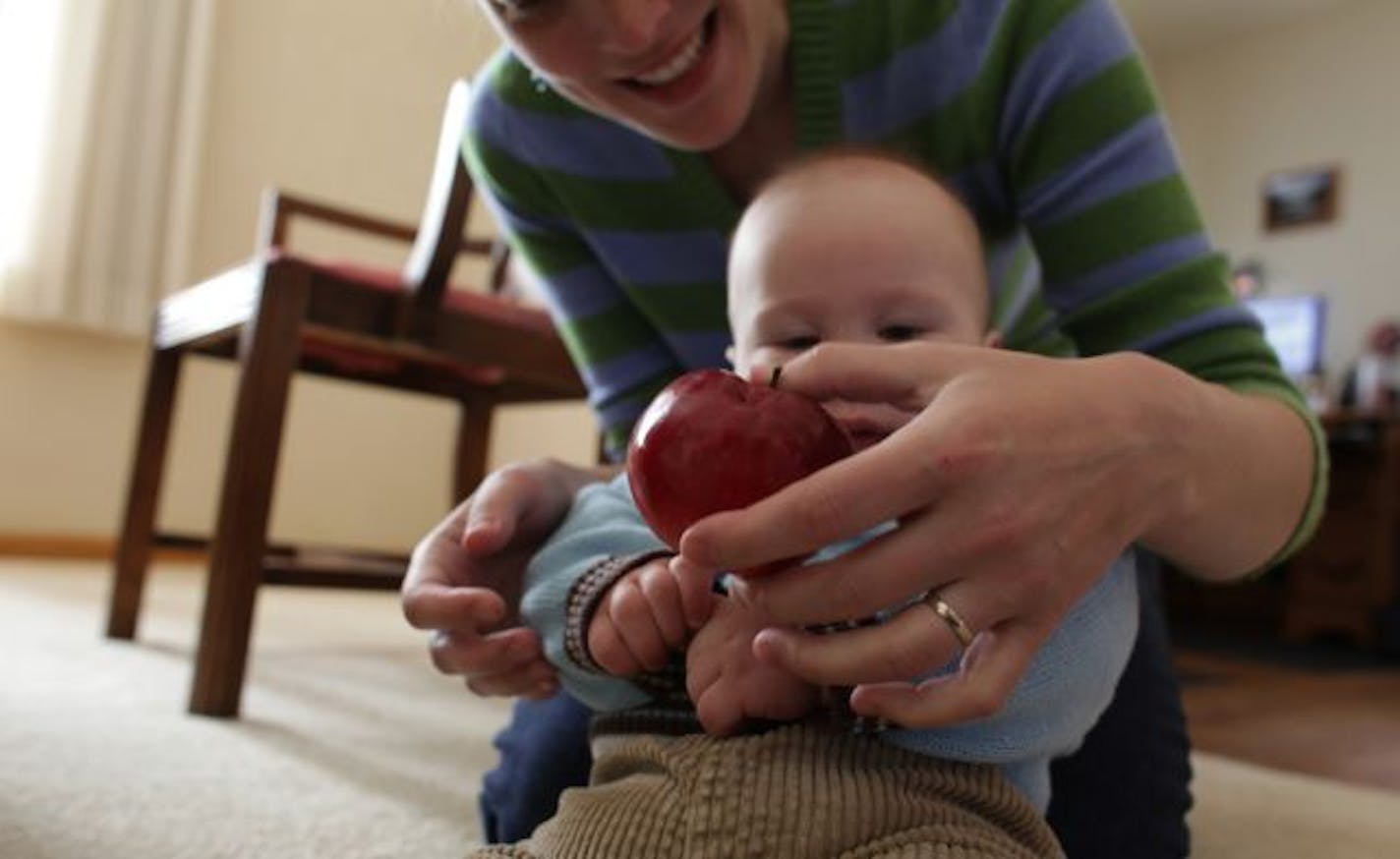 Jen Erickson, a teacher in Albert Lea, gave her son an apple to gum on. Erickson's family has been active in the five-month project.