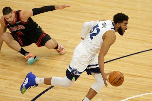 Minnesota Timberwolves center Karl-Anthony Towns (32) leaves Chicago Bulls center Nikola Vucevic (9) on the floor in the first quarter during an NBA b