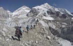 FILE - In this Feb. 22, 2016 file photo, international trekkers pass through a glacier at the Mount Everest base camp, Nepal. A Nepalese official says
