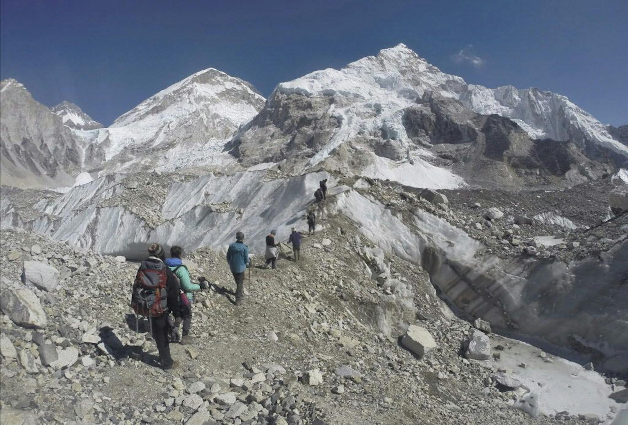 FILE - In this Feb. 22, 2016 file photo, international trekkers pass through a glacier at the Mount Everest base camp, Nepal. A Nepalese official says Sherpa workers are fixing the final route to the summit of Mount Everest and the first climb of the season could be days away.