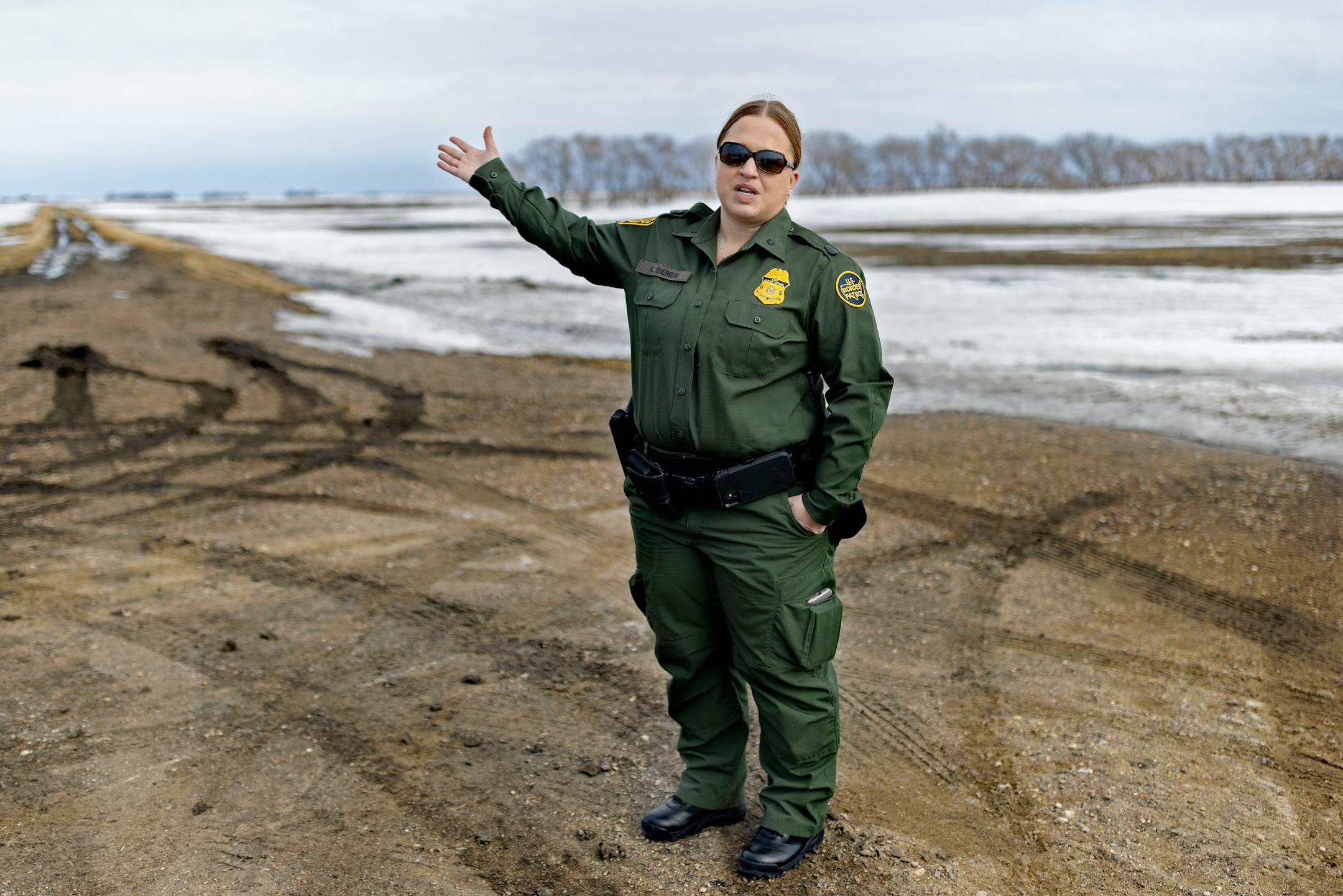 Customs and Border Patrol agent Kathryn Siemer stands just 1/2 mile from where a family of four from India was found frozen to death near Pembina, Minn., on Monday, March 21, 2022. She said her team took in five other Indian citizens who were carrying backpacks with baby items that prompted them to do a search and the Canadian patrol found the family on the Canadian side.