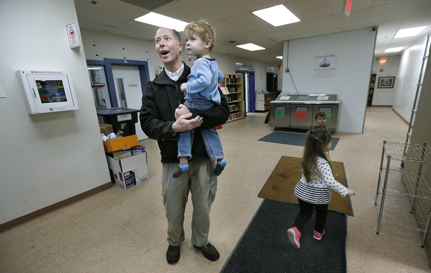 Former pastor Jason Berry greeted children before he helped feed them a free lunch at the Anoka Community Mission, Tuesday, January 10, 2017 in Anoka, MN. Jason Berry stepped away from the church to become a missionary. A midnight relevation gave him the idea to meet hurting people where they're at, rather than expect them to venture inside a church. Berry now spends his days running a crisis center and social services nonprofit in Anoka, where visitors can get a hot meal, clothes, childcare and