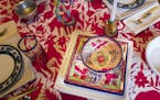 Anne Damon, owner of Zinnia Folk Arts, sets a colorful table at home in Minneapolis.