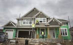 Construction workers build a home in the new Lennar Homes development called The Reserve at Spring Meadows in Plymouth.